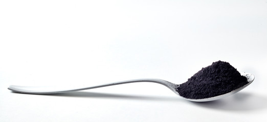 Spoon heaped with pulverised organic charcoal