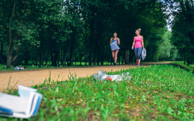 Two girls picking up trash while plogging outdoors