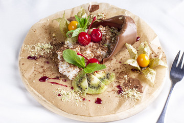 Chocolate dessert Mother's plant with cream and fresh fruits on round board