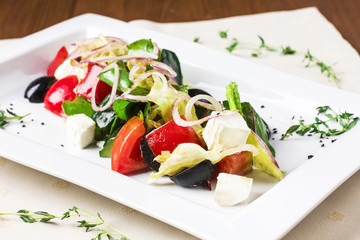 Classic Greek salad on white square plate