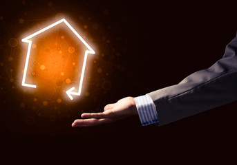 Conceptual image with hand pointing at house or main page icon o