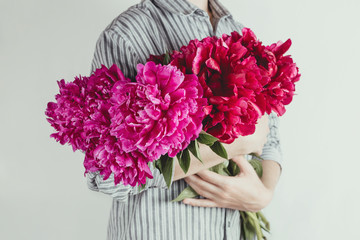 Faceless portrait of woman holding bouquet of violet and purple flowers, selective focus