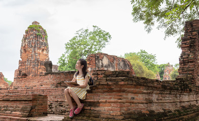 Asian cute girl relaxing outdoors while drawing,Student enjoy learning at historical, park,Wat Mahathat,Ayutthaya,Thailand