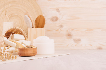 Oatmeal flackes and white cream, bath accessories on beige wooden shelf, rustic cosmetic style,...