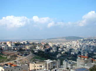 Fototapeta na wymiar Panorama of cloudy blue sky above Nazareth city at the foot of the hills on the horizon.