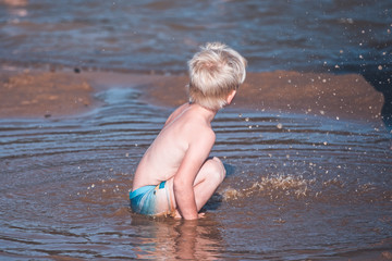 A small child splashing in the coastal water