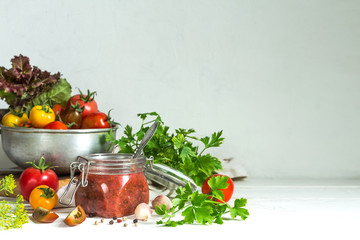 Tomato sauce and fresh tomatoes, garlic, dill, parsley on a light wooden background still life in vintage rustic style