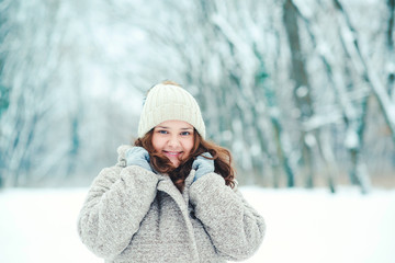Teenage girl posing in snowy forest. Winter holidays concept. Girl outdoors in cold day. Winter fashion, sales and lifestyle concept. Winter woman portrait. Warm woman outfit. Winter mood.
