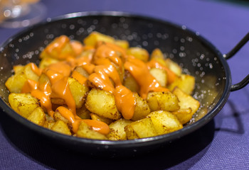 Patatas Bravas (Spanish Fried Potatoes) with spicy orange-colored salsa brava (brava sauce) or alioli (aioli). Patatas Bravas is a classic and very popular tapas dish served throughout Spain.