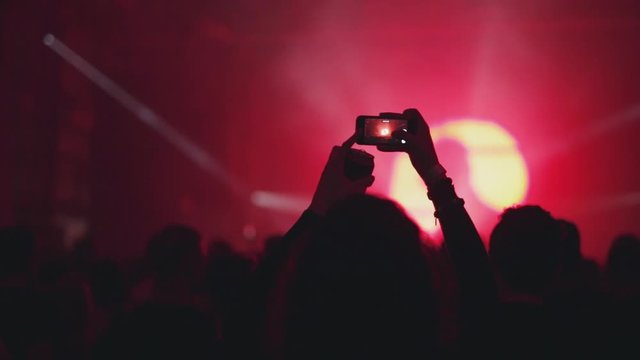 Girl filming concert or party with her smartphone camera.