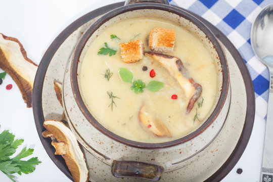 Cream-soup with dried boletus mushroom with croutons on white table