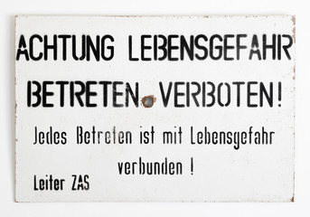 East - West German border warning sign on a white wall. Found near Wernigerode in 1990 following the reunification of Germany at the end of the Cold War.