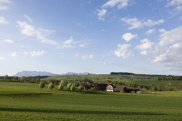 Farm in central Switzerland on a sunny spring day near Nottwil. In the background Mount Pilatus