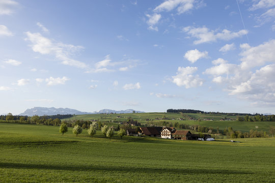 Farm in central Switzerland on a sunny spring day near Nottwil. In the background Mount Pilatus