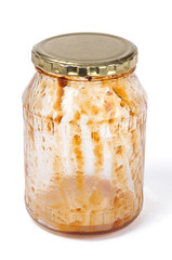 Empty jar of apricot jam with lid on a white background. Front view.