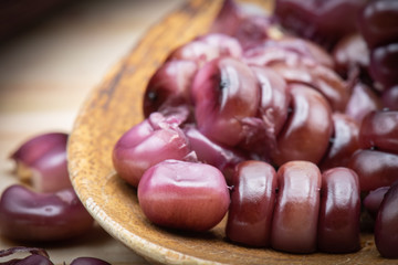 Purple corn grains in wooden spoon