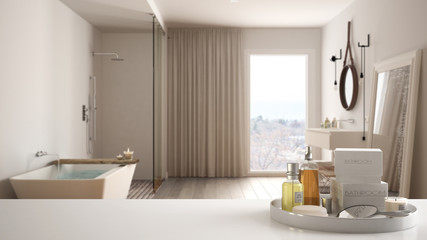 Spa, hotel bathroom concept. White table top or shelf with bathing accessories, toiletries, over blurred luxury bathroom, modern architecture interior design