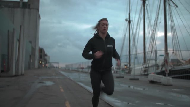 Girl running on harbor, pushing her self.