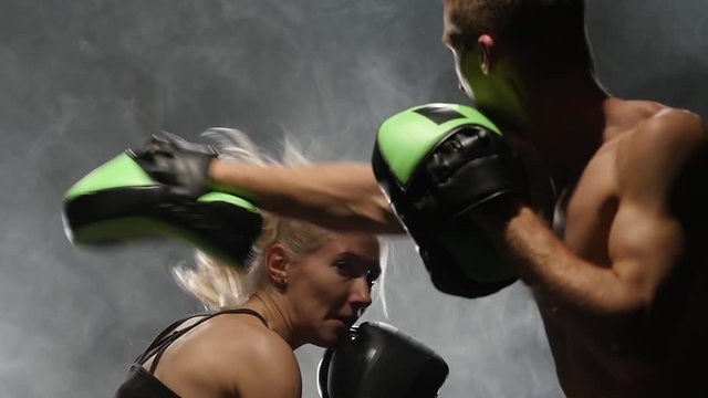 Guy and the girl on the boxing. Light from behind. Smoke background. Slow motion
