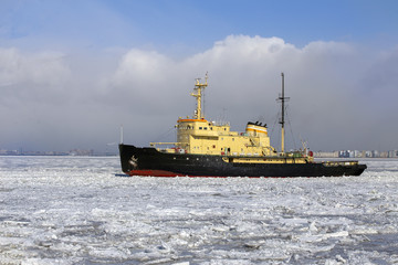 Icebreaker ship breaks ice and moves across the frozen sea
