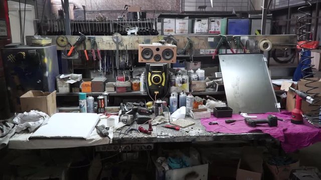 Complete workbench with a wall of tools in a workshop. Clip. Table with tools in the garage
