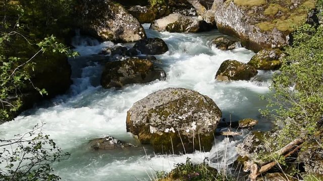 Glacier river passing some large boulders. Location river Jordalselvi in Hordaland, Norway.