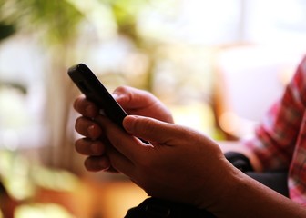 People hand using smartphone closeup interior blur background. Concept of Technology