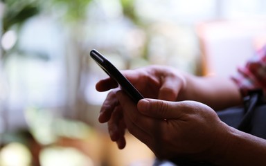 People hand using smartphone closeup interior blur background. Concept of Technology