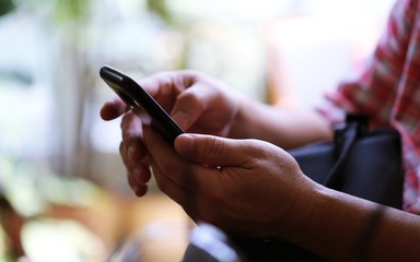 People hand using smartphone closeup interior blur background. Concept of Technology