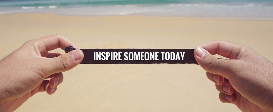 Motivational and inspirational quote - ‘Inspire someone today’ written on a piece of paper. With vintage styled background.	