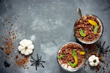 Halloween worms and dirt dessert - chocolate sponge cake crumbs, whipped cream and gummy worms in cups
