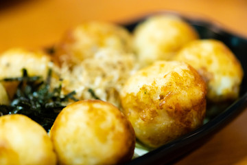 traditional japanese local food takoyaki.delicious seafood takoyaki with seaweed on black plate.japanese chef cook takoyaki for customer at japanese restaurant and cafe.takoyaki.