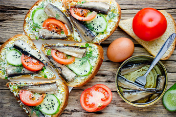 Smoked sprat fried sandwiches with boiled egg, tomato, cucumber and sesame