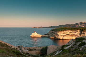 Fototapeta na wymiar Sunlight on lighthouse at entrance to Bonifacio harbour in Corsica