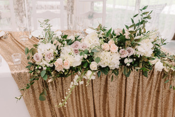 Beautiful pink, white and pastel roses and white hydrangea on a wedding table.