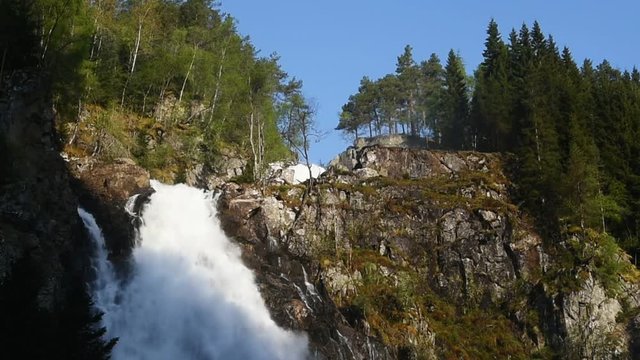 The waterfall Espelandsfossen just south of Odda in Hordaland, Norway. Here on a sunny morning in late May with only the top part in sunshine.