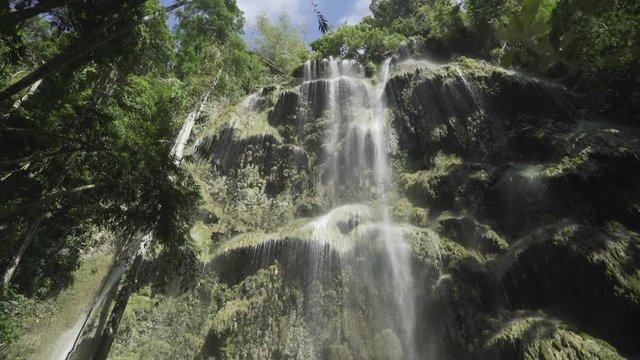 Tilt up slow reveal of Tumalog Falls in Philippines.