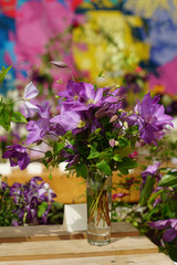 beautiful bouquet of clematis flowers in transparent wase