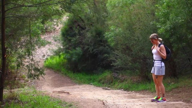 Woman in Free Stone Creek, Australia, admiring the surrounding beauty of the outdoors during a hike. Day time Medium shot.