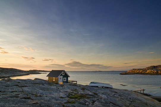 Wooden hut on rocky coast with sunset, Smoegen, Bohuslaen, Sweden, Scandinavia, Europe