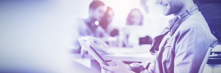 Smiling young man using digital tablet