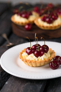 homemade tartlet, filled with custard and topped with cherries, rustic style