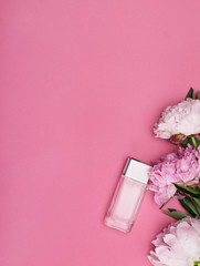 Obraz na płótnie Canvas bottle of perfume and peony flowers