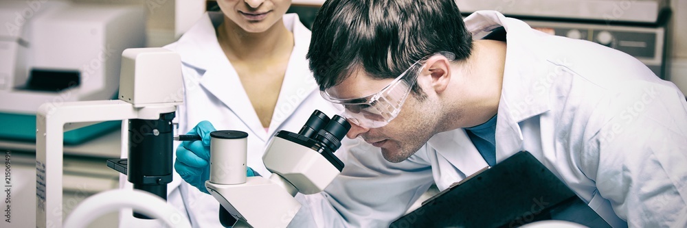 Poster two scientists observing something with a microscope