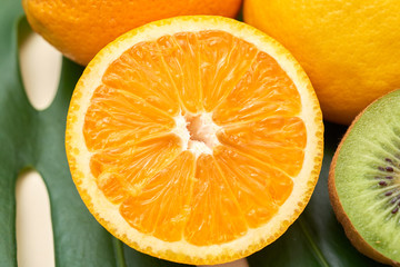 Close-up shot of orange half with vivid juicy fiber from above in composition with fruit