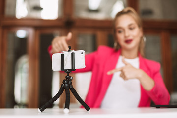 Close up young female blogger recording new video on smartphone isolated