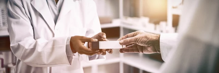 Abwaschbare Fototapete Apotheke Abgeschnittenes Bild einer Patientenhand, die eine Schachtel vom Apotheker nimmt