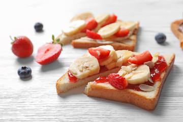 Tasty toast bread with banana and strawberry on light background, closeup