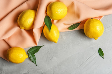 Composition with lemons, leaves and fabric on light background