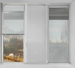 Window with open blinds and beautiful view of landscape
